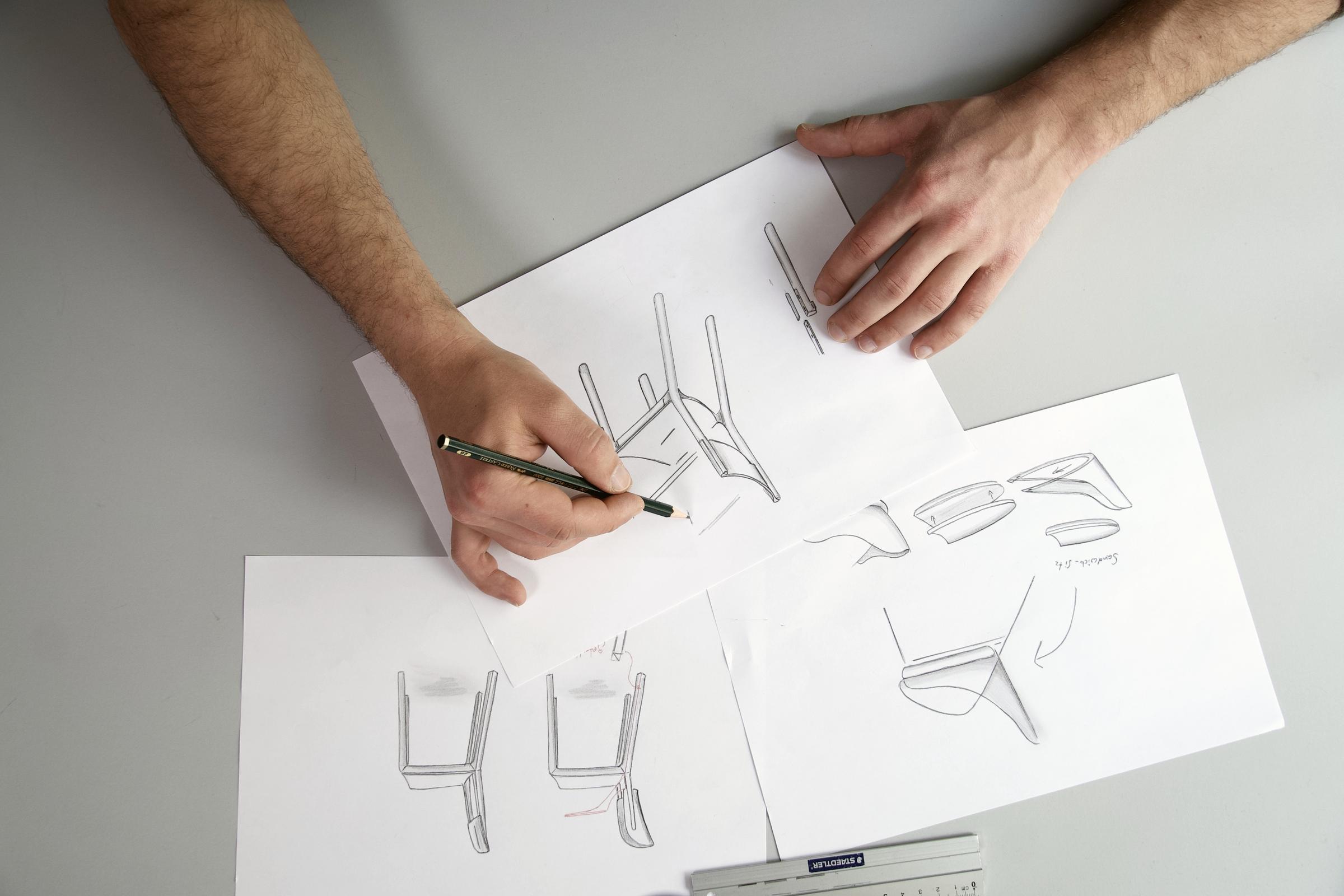 Hand sketching a chair design in pencil