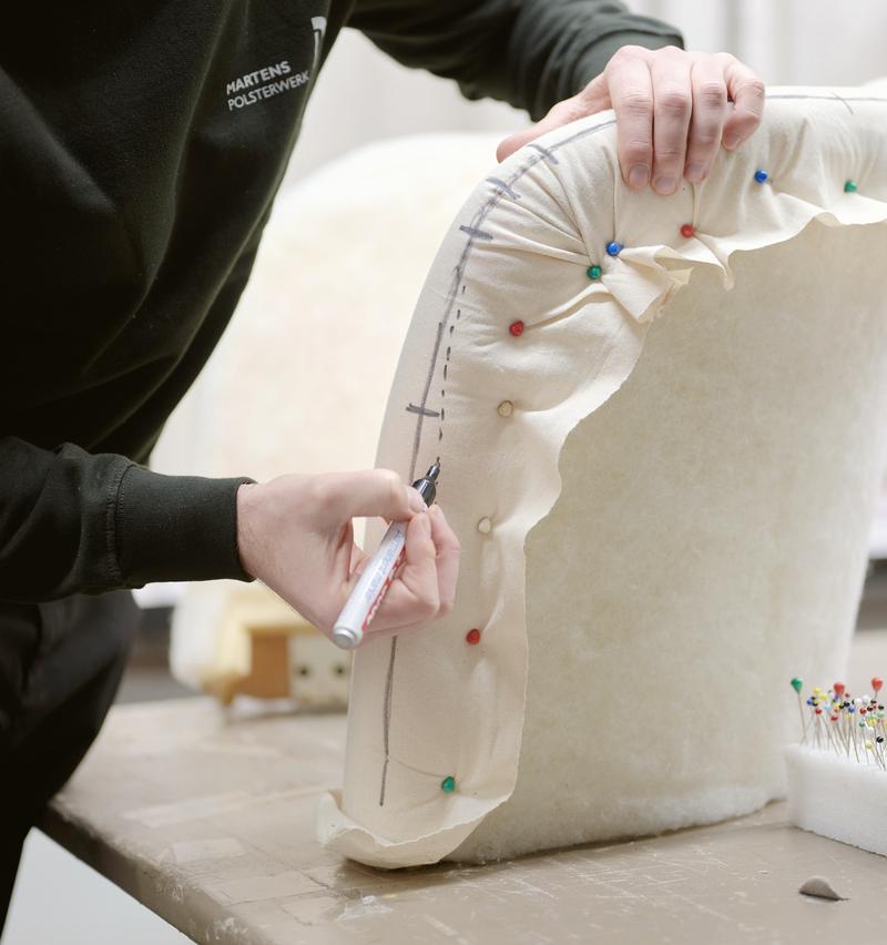 Developer drawing seam lines on an upholstery pattern