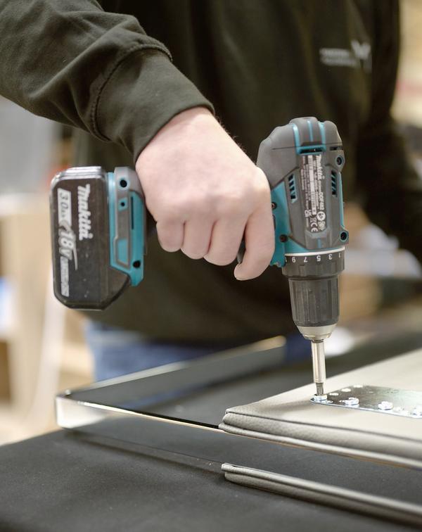 Upholstered part being assembled with a cordless screwdriver