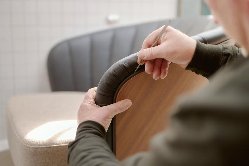 Hands checking the edge of an upholstered backrest