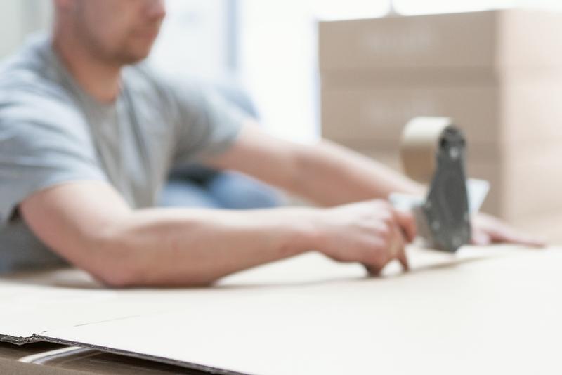 Sealing a box with a tape dispenser