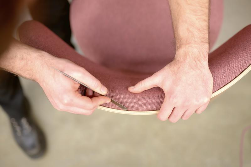 Hands checking the edge of an upholstered chair