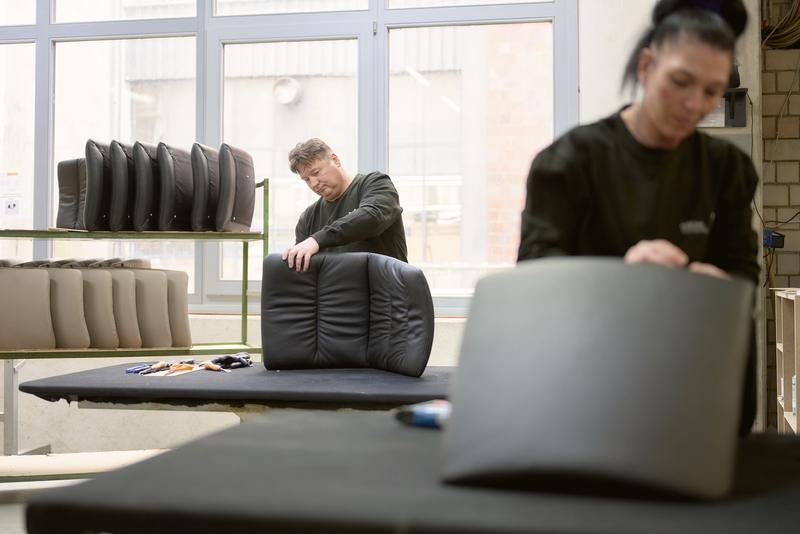 Two upholsterers covering backrests together