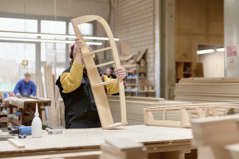 A curved wooden frame being checked