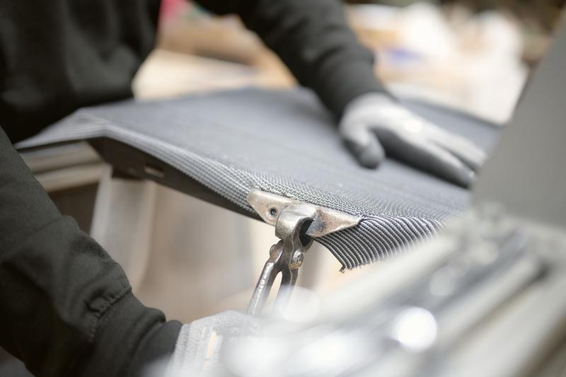 Gloved hands working on an upholstered part