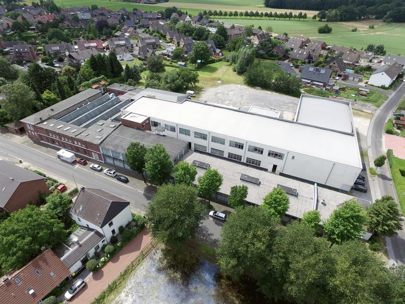 Aerial view of the factory in Kevelaer between trees and a pond