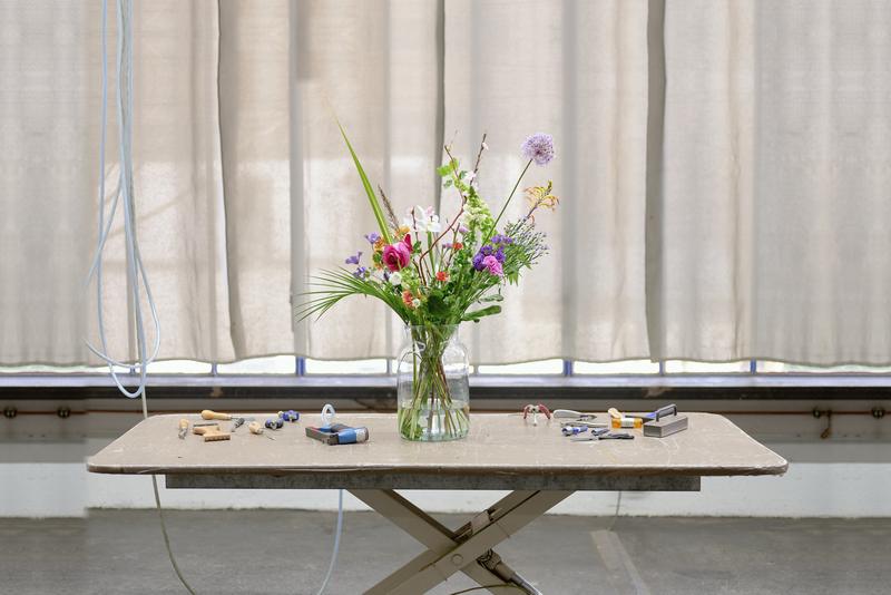 Workbench with flowers and tools in daylight