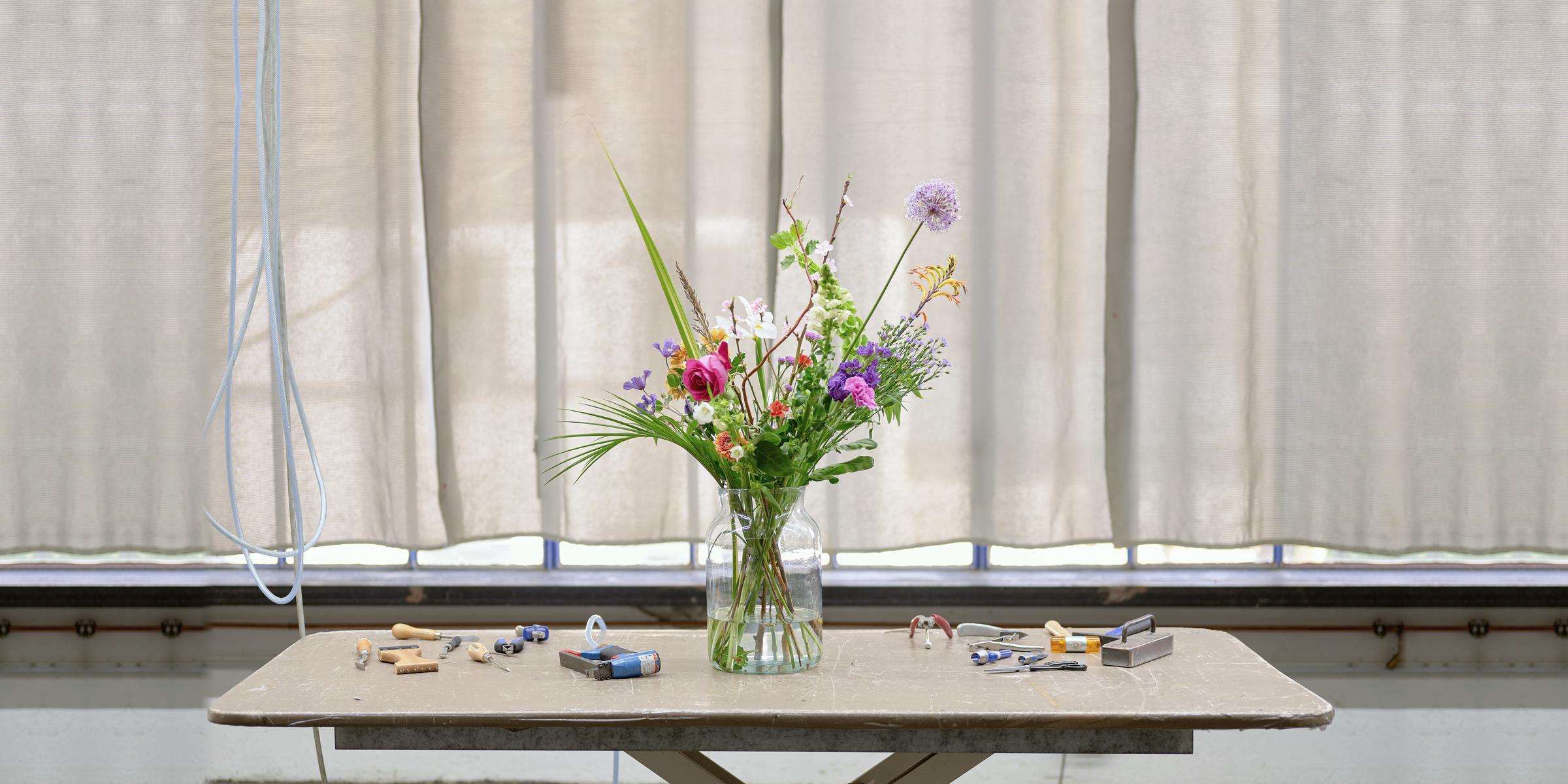Workbench with flowers and tools in daylight