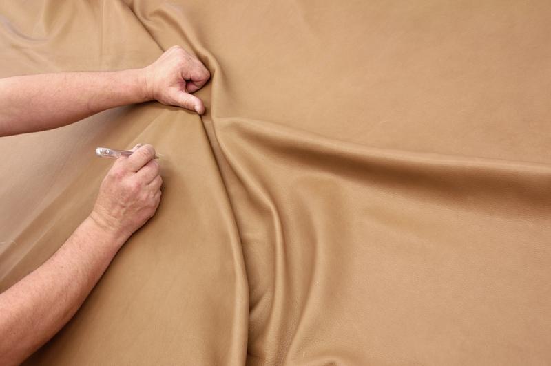 Hands smoothing out an upholstery fabric